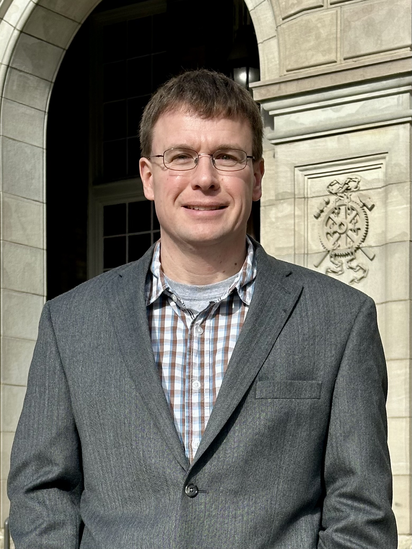 Photo of Mike Pliemann in gray suite coat.